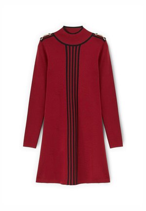 Robe tricot rouge avec un col haut, présentant des rayures verticales noires et des accents en métal doré aux épaules. Manches longues et forme évasée.