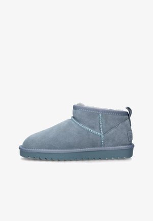 Stivaletti azzurri chiari in suede con una morbida fodera in pelliccia, caratterizzati da un design cucito, una linguetta e una suola in gomma testurizzata.