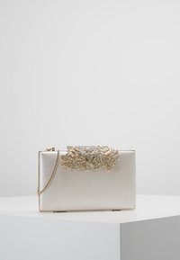 Borsa clutch con finitura argento metallico, forma rettangolare, decorata con un ornamento floreale scintillante in oro e cristalli. Tracolla a catena collegata.
