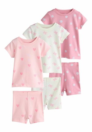 Tre completi di pigiami per bambini piccoli, ciascuno con magliette a maniche corte e pantaloncini in rosa, bianco e fantasie di cuori, fiocchi e pois.