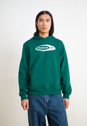 Zöld kapucnis pulóver pamut keverékből, elülső zsebbel és fehér Reebok logóval a mellkasán. Laid-back fazon, bordázott mandzsettákkal és szegéllyel.