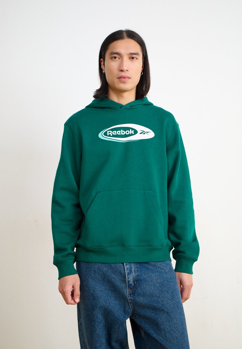 Hanorac verde din amestec de bumbac, cu o buzunar frontal și un logo alb Reebok pe piept. Croială casual, cu manșete și tiv din bumbac ribat