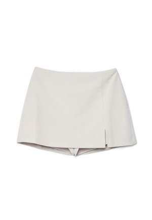 Bež visokerožni skort z majhnim sprednjim razrezom na desni strani, ki združuje videz krila s kratkimi hlačami spodaj.