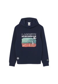 Mörkblå hoodie med känguruficka, med ett grafiskt tryck av en tennisbana och texten "LACOSTE ROLAND GARROS CLUB" i vitt.