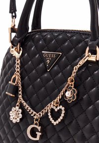 Borsa a tracolla nera trapuntata con catena in tono dorato, con charm: un lucchetto, un fiore, un cuore e la lettera "G". Logo a triangolo sul davanti.