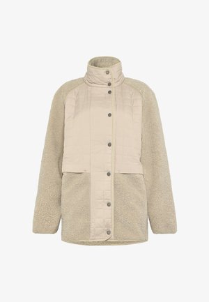 Beige fleecejakke med quiltet frontpanel, høj krave, trykknapper ned langs midten og lange ærmer.