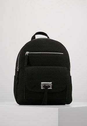 Sac à dos noir avec une surface texturée, doté d'une poche avant avec un fermoir argenté, fermeture à zip et bretelles réglables.