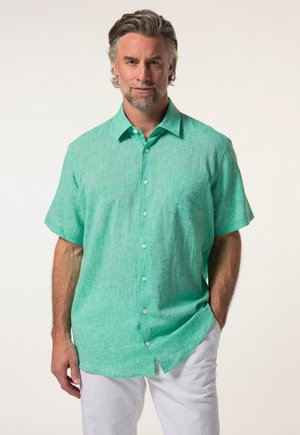 Korte mouwen, knoopsluiting shirt in lichtgroen linnen met een gestructureerde afwerking en een borstzak, gecombineerd met witte broeken.