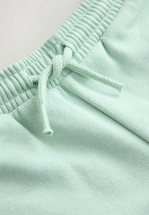 Hellgrüner Stoffbund von Jogginghosen mit elastischem gerafftem Nähten und gebundenem Kordelzugknoten.