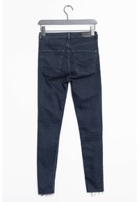 Jeans skinny de color azul oscuro, confeccionados en denim, con una cintura de altura media, bolsillos traseros y detalles de dobladillo sin terminar en los tobillos.