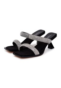 Zwarte haksandalen met dubbele strappy versiering van rhinestones en een vierkante neusontwerp, met een lage blokhak en een zachte suède-achtige textuur.