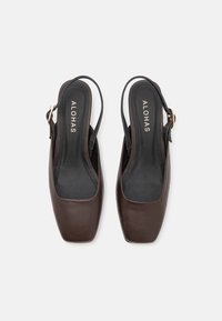 Chaussures slingback en cuir marron avec un design à bout carré. Texture lisse, style minimaliste, dotées d'une boucle dorée pour l'ajustement.
