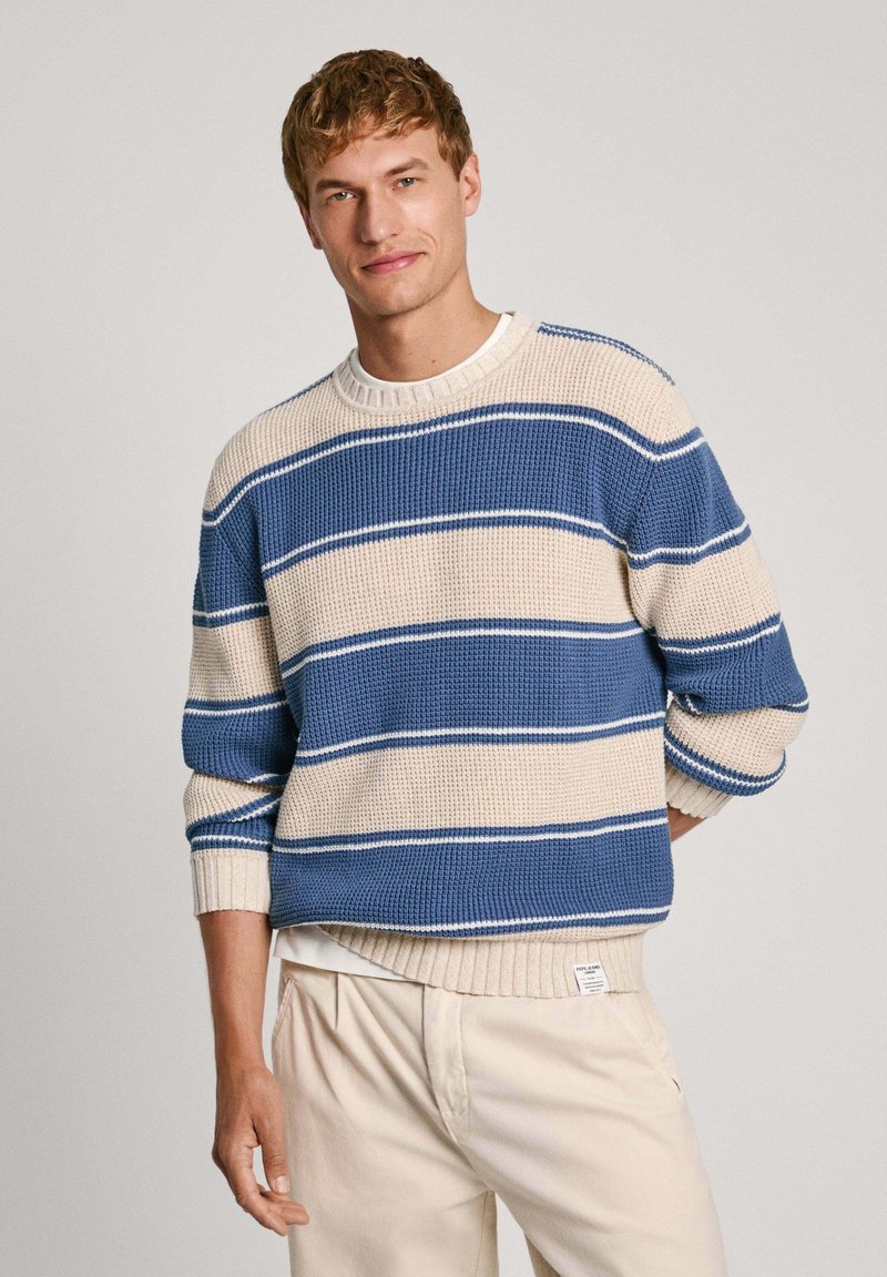 Kootud sviiter siniste ja kreemjate horisontaalsete triipudega, ribatud varrukate ja alumise äärega, millel on tekstureeritud viimistlus ja ümmargune kaelus.