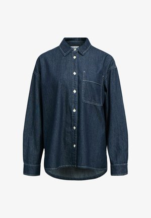 Chemise en denim bleu foncé, équipée d'un devant à boutons, d'un col pointu, de manches longues et d'une poche poitrine. Coutures blanches discrètes visibles.