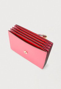 Ružová kožená peňaženka so šiestimi priehradkami na karty, zlatými kovaniami a zapínaním na patent. Má hladkú textúru a kontrastný červený vnútorný priestor.