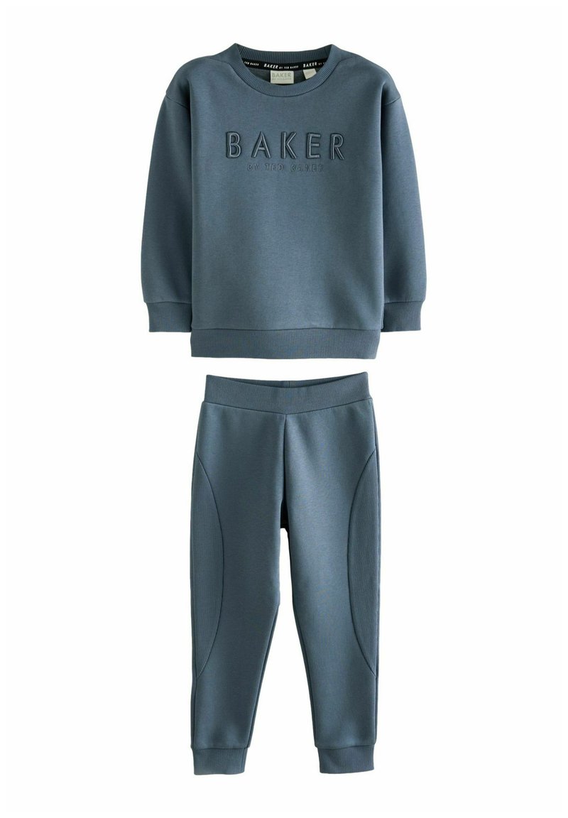 Dwuczęściowy zestaw dresowy w miękkim niebieskim materiale. Bluza z podwyższonym napisem "BAKER", natomiast spodnie mają gładkie i teksturowane akcenty po bokach.