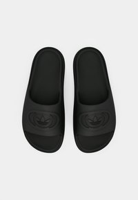 Czarne klapki na platformie z fakturowaną gumową górą, ozdobione wypukłym logo na pasku oraz gładką wkładką dla komfortu.
