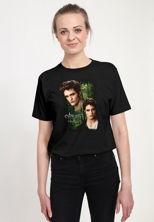 T-shirt noir avec une impression graphique de deux visages sur un fond de forêt verte, avec le texte "Edward la saga Twilight" en dessous.
