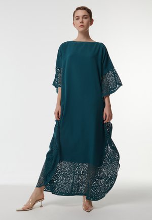 Robe turquoise en tissu léger, avec une silhouette fluide, des détails en dentelle élaborés sur les manches et l'ourlet, avec des accents transparents à la base.