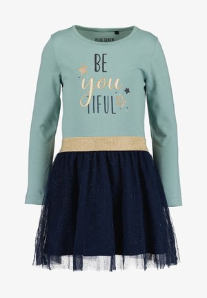 Robe à manches longues avec un haut vert menthe, une jupe en tulle marine, une ceinture scintillante dorée et une inscription « BE you tiful » accompagnée d'étoiles et d'accents.