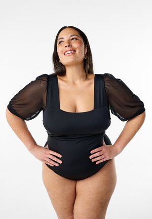 Zwarte tankini met vierkante halslijn en doorschijnende pofmouwen. Soepele textuur met een aansluitend ontwerp, ideaal voor zwemkleding.