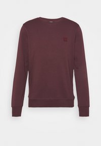 Bordowa bluza z bawełnianej mieszanki, z okrągłym dekoltem, długimi rękawami, ściągaczami na mankietach i teksturowaną naszywką z logo na piersi.