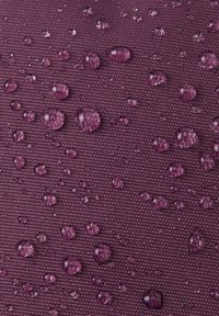 Teksturowany materiał w głębokim purpurowym kolorze z kroplami wody na powierzchni, podkreślający jego właściwości wodoodporne oraz charakterystyczny wzór splotu.