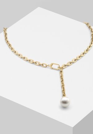 Collier chaîne en or avec des maillons ovales, présentant un pendentif unique en perle blanche suspendue sur une surface blanche minimaliste.