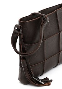 Ciemnobrązowa torebka ze skórki o teksturze, z plecionym kwadratowym wzorem, regulowanym paskiem i chwostem z metalową zawieszką.
