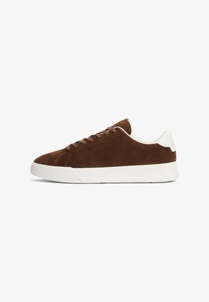 Sneaker in suede marrone con suola in gomma bianca, punta rotonda e lacci piatti. Caratterizzato da un design minimalista e accenti tessili a contrasto.