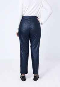 Navyblauwe satijnen broek met een relaxte pasvorm, elastische tailleband, twee achterzakken en een gladde textuur. Geschikt voor casual wear.