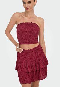 Bordeaux tweedelig outfit met een strapless, gerimpelde top en een gelaagde, gerimpelde rok, met een bloemenpatroon en een elastische tailleband.