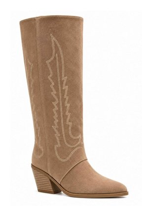Botte western en daim beige, hauteur genou, avec coutures décoratives, talon bloc et bout pointu, présentée sur un fond blanc uni.