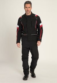Schwarze Motorradjacke mit roten und weißen Akzenten, die ein strukturiertes Design, mehrere Reißverschlüsse und gepolsterte Bereiche an Ärmeln und Hosen bietet.
