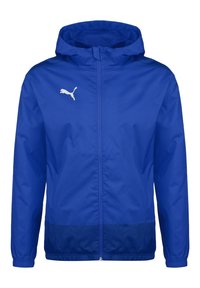 Veste coupe-vent à capuche Puma bleue avec fermeture éclair à l'avant et logo Puma blanc sur la poitrine gauche, poignets élastiques et bandeau inférieur bleu foncé.