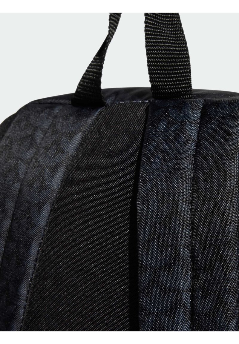 Mochila de tela negra con un diseño texturizado, que cuenta con asas negras resistentes y una forma elegante y redondeada.