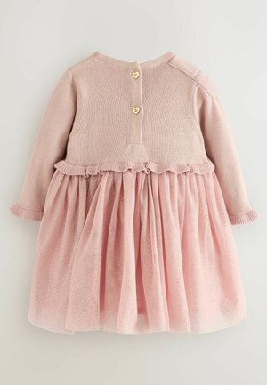 Abito rosa chiaro con top in maglia e gonna in tulle con dettagli glitterati. Chiusura posteriore con bottoni a forma di cuore. Dettaglio della vita arricciata.