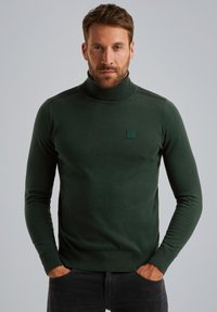 Grüner Rollkragenpullover aus weichem Strick mit schlanker Passform. Verfügt über ein kleines rechteckiges Logo auf der Brust sowie gerippte Bündchen und Kragen.