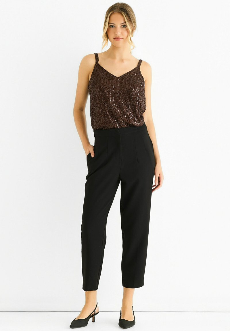Bronze sequined tank top with V-neck, paired with high-waisted black trousers featuring pleats, and black pointed-toe heels.