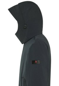 Zwarte waterdichte jas met een hoge kraag en verstelbare capuchon. Voorzien van een gestructureerde stof en een merkpatch op de mouw.