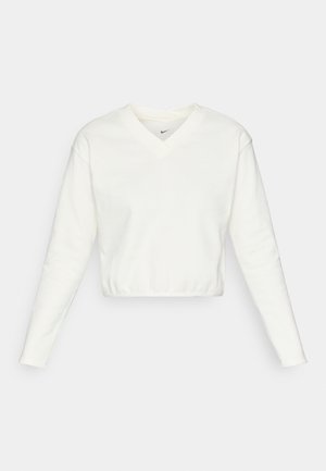 Skrajšani beli pulover z dolgimi rokavi, z V-izrezom in logotipom Nike na prsih. Narejen iz mehke tkanine z gladko teksturo.