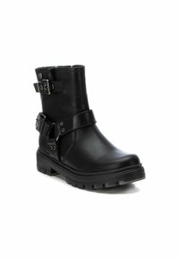 Botas de combate negras hechas de cuero liso, con dos correas ajustables y hebillas plateadas, punta redonda y suela resistente.