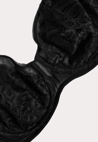 Soutien-gorge en dentelle noire avec armatures. Présente des bonnets texturés et des détails en tulle transparent. Bretelles réglables et fermeture à crochet dans le dos.