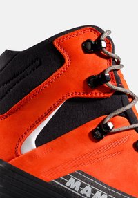 Hochschuh-Wanderschuh mit schwarzem Stoff-Obermaterial und leuchtend orangefarbenen Wildlederakzenten. Metallische Ösen und Schnürsenkel verbessern die Funktionalität.