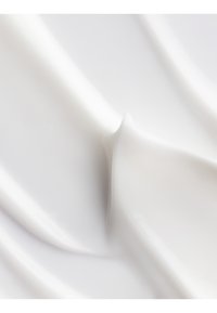 Crème ou lotion blanche avec une texture lisse et brillante, présentant des courbes et des vagues subtiles, mettant en valeur sa consistance épaisse et riche.