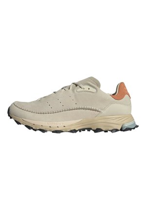 Beige Wildlederschuh für den Sport mit strukturierter Oberfläche, Gummisohle und Akzent aus braunem Leder an der Ferse. Verfügt über durchbrochene Details und ein leichtes Design.