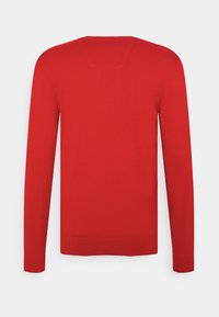 Maglione rosso a girocollo con maniche lunghe, trama a maglia, polsini e orlo a coste, caratterizzato da un piccolo dettaglio di cucitura sul retro del collo.
