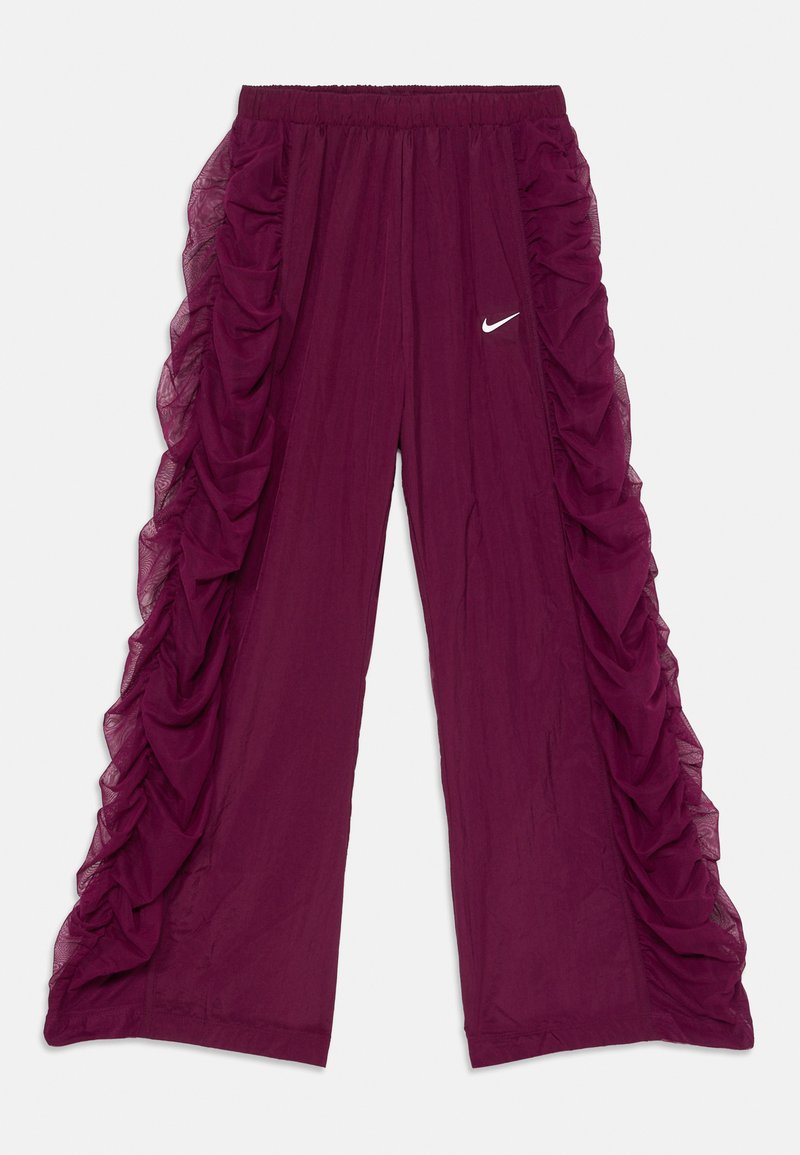 Sarkanas bikses ar caurspīdīgiem, viļņotiem akcentiem sānos, elastīgu jostasvietu un mazu balto Nike logo priekšpusē. Gluda tekstūra.