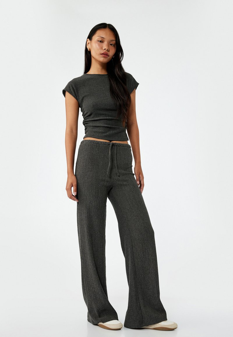 Grijze gebreide top met korte mouwen, gecombineerd met bijpassende wijde broek met een elastische taille. Soepele textuur, casual pasvorm.