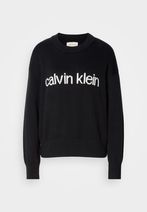 Juoda ilga rankovė megztinis su apvaliu kaklu ir baltu "calvin klein" logotipu, esantis centre priekyje.